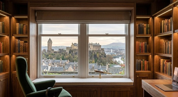 A full-wall example of custom-fitted joinery integrated into an old, period Stirling property. The built-in walnut library maximizes space in an awkward corner while protecting the historical window view.